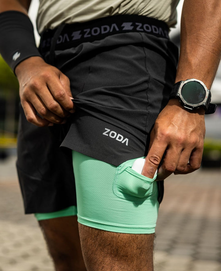 Person wearing black and green athletic shorts with 'Zoda' branding. Zoda.sg pulse collection 4