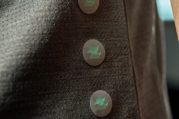 Close-up of ZODA logo buttons on technical fabric